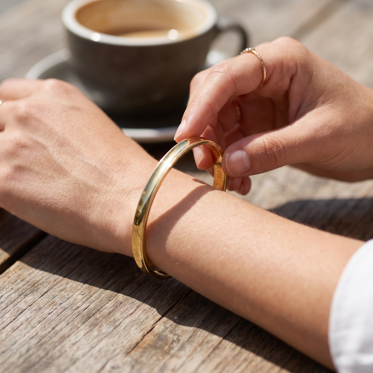 Bracelet jonc gravé porté au poignet, gravure intérieure visible à la lumière