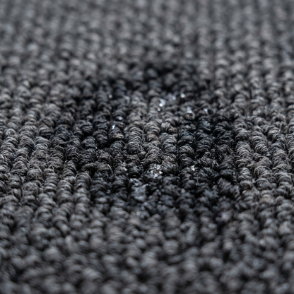Gros plan de gouttes absorbées par un tapis d'entrée