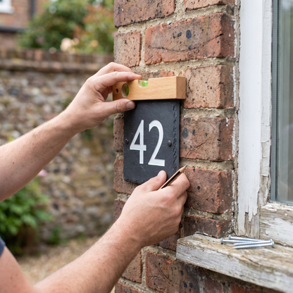 Installation d'une plaque de numéro civique au mur