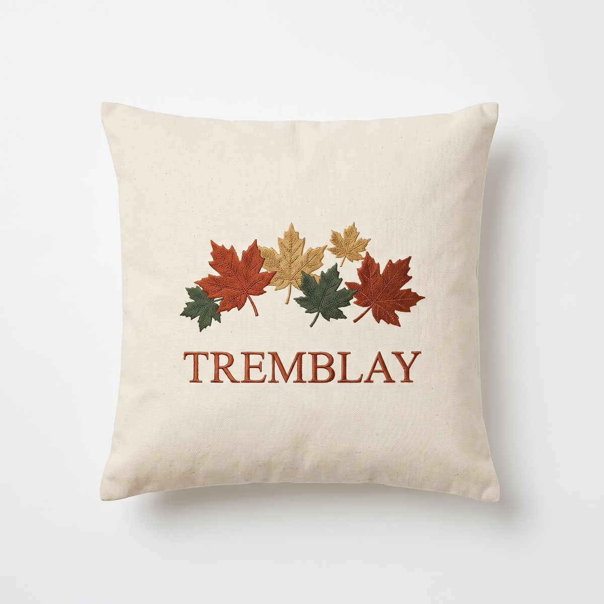 Housse de coussin écrue brodée de feuilles d'érable et du nom de famille